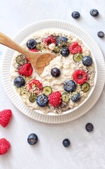 Vegan Porridge bowl with fresh fruits on a white plate and white background