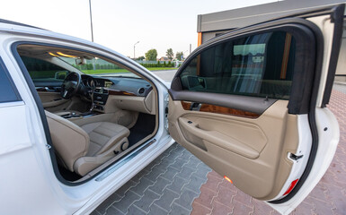 Experience the exquisite luxury of a sedan interior showcasing an open door and featuring premium leather seats, all designed within a stunning modern setting that exudes sophistication and elegance