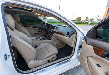 This luxury car features a beautifully crafted interior with elegant beige upholstery and modern design, enhancing sophistication, comfort, and enjoyment for an unparalleled driving experience