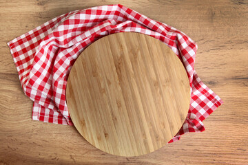  Round wooden board with red checked tablecloth on rustic wooden table kitchen cooking or baking...