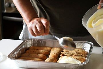 Woman making Tiramisu dessert in the kitchen