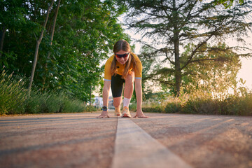 Runner prepares for a sprint at sunset in a peaceful outdoor setting