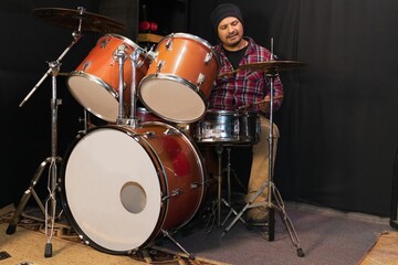 Man playing acoustic drums in a studio