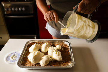 Woman making Tiramisu dessert in the kitchen
