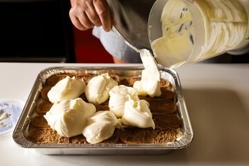 Woman making Tiramisu dessert in the kitchen