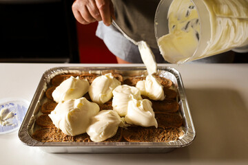Woman making Tiramisu dessert in the kitchen