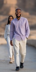 Obraz premium Smiling young african couple walking outdoors in casual attire