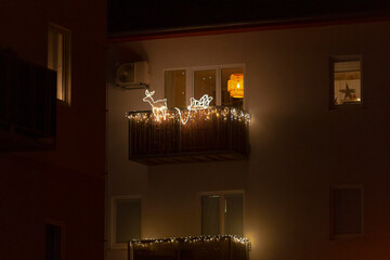 A beautifully decorated balcony adorned with sparkling Christmas lights is brightly illuminated during the enchanting hours of night