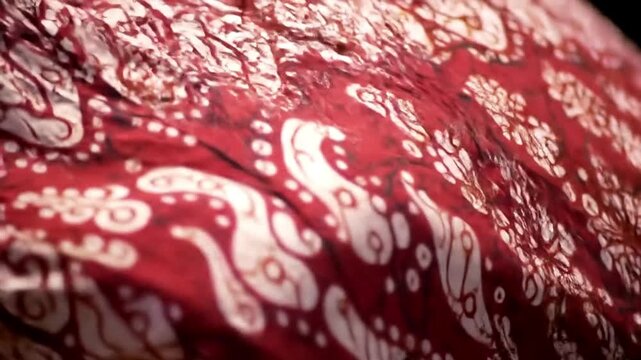 Traditional red batik fabric with intricate patterns creating visual texture
