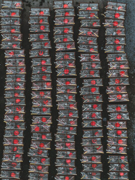 Aerial view of tightly packed crab pots displaying vibrant red buoys against a dark, textured backdrop, creating an industrial mosaic, Unalaska, Alaska, United States.