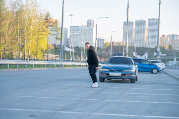 Caucasian man pulling a car with a rope. 