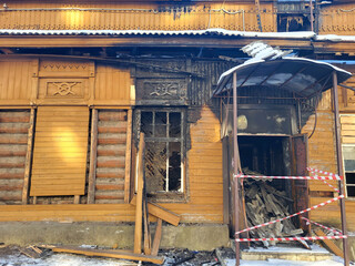 The walls and entrance to a wooden brown house that were burned during the fire