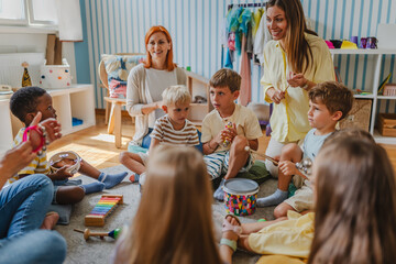 Diverse group of preschool children and teachers playing musical instruments in a colorful...