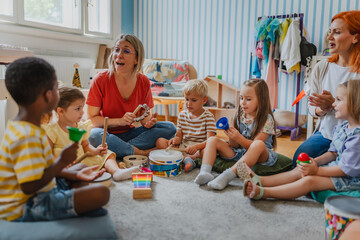Diverse group of preschool children and teachers playing musical instruments in a colorful...