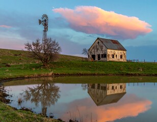 Rustic barn at sunset, reflecting in pond