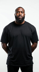 Fototapeta premium Portrait of a tough African American bodyguard in oversized black t-shirt on white background. 
