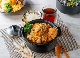Spicy Pork and Kimchi Pot with Melted Cheese and broccoli in pot Served with Rice and Iced Tea side view of Taiwan food