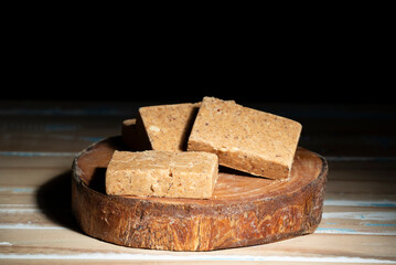 Wooden cutting board with sweets made from peanuts known in brazil as pacoca.