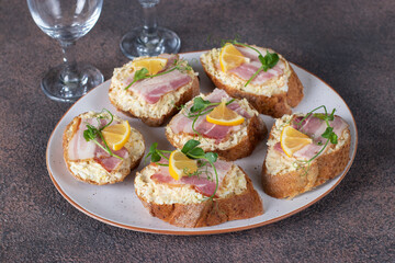 Homemade sandwiches with bacon, melted cheese and lemon