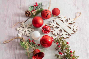 Flat lay of Christmas decorations in red and white on rustic wood background, including baubles,...