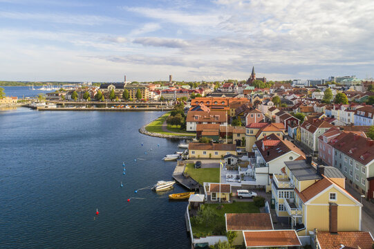 Aerial view of the picturesque harbor dotted with boats, leading to a cityscape crowned by the spire of St. Petri Church, Vastervik, Kalmar County, Sweden.