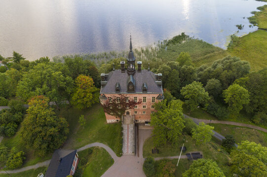 Aerial view of the imposing Wiks Castle, embraced by vibrant green trees and tranquil waters, a picturesque scene of history and nature, Wiks slott, Uppsala, Sweden.