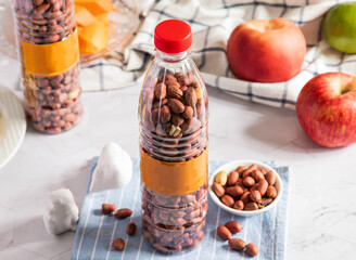 Peanuts in Bottles with Fresh Apples side view of healthy organic food