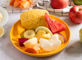Colorful Fresh Mixed Fruit Platter with Pineapple, Watermelon, Kiwi, and Tropical Fruits on Yellow Plate