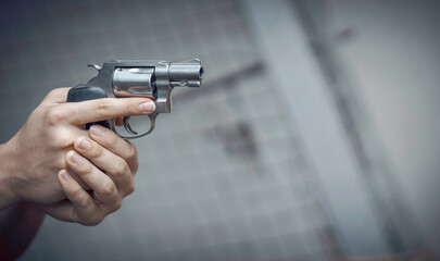 A man is holding a silver revolver gun to protect himself from enemies.