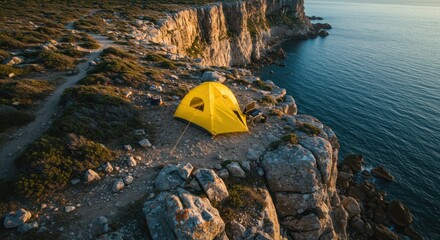 Yellow tent cliff ocean sunrise