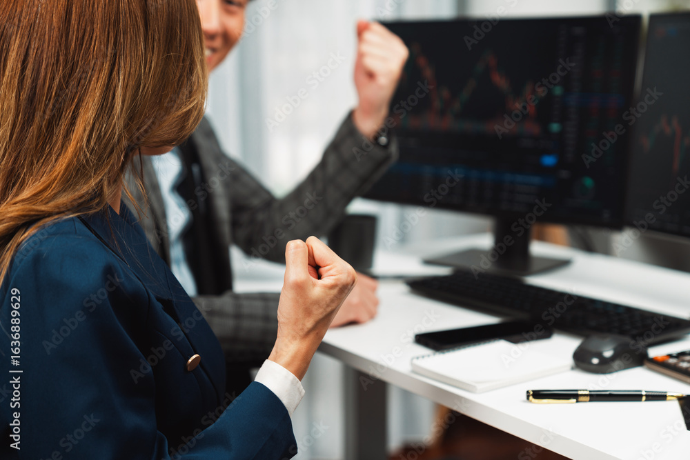 Poster cropped successful in smiling business partners raising fist up with profit stock market looking on 