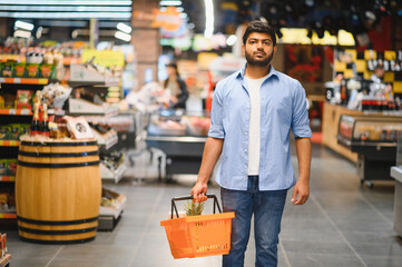 Indian man shopping for groceries in supermarket with basket