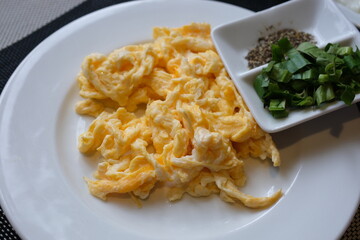 Scrambled eggs garnish dramatic morning light as scrambled eggs on a plate emit warmth. The play shadows and highlights creates a visual textures and flavors. High quality 4k footage. High quality