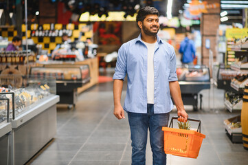 Indian man shopping for groceries in supermarket with basket