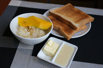 Sweet sticky rice with mango on wooden background. Mango is popular tropical fruit for dessert in...