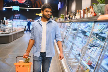 Young indian man shopping for groceries in supermarket
