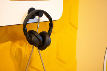 Stylish Black Headphones on Yellow Wall