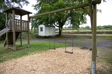 Empty playground swings on sunny day