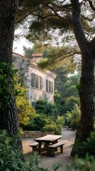 Charming Rustic House Surrounded By Lush Greenery And Trees. Tranquil Outdoor Setting With Wooden Picnic Table
