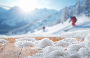Snow-covered empty copy space for product placement. Mockup and blurred background of snowy mountains, ski slopes and bright winter day. Concept of winter holidays, skiing, alpine outdoor activities.