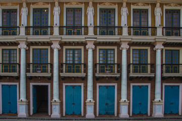 Obraz premium Colorful Colonial-Style Building Facade with Blue Doors and Sculptures in the Philippines