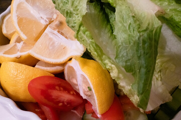 A fresh arrangement of sliced lemons, ripe tomatoes, and crisp lettuce, showcasing vibrant colors...
