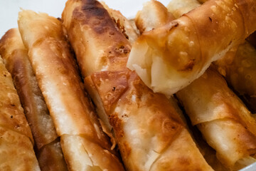 Crispy, golden-brown spring rolls filled with savory ingredients, perfect for snacking or as an appetizer