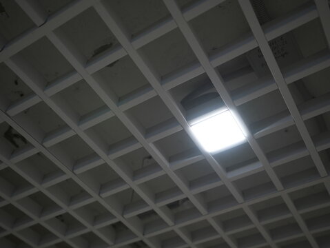 Grid ceiling with integrated LED light in modern commercial or public interior

