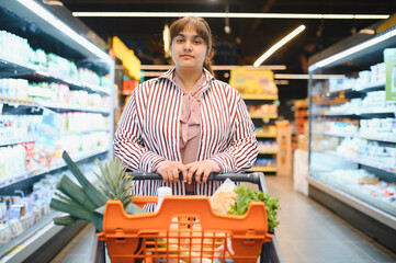 Indian woman pushing shopping cart in grocery store
