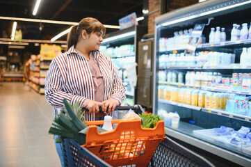 Indian woman choosing dairy products in grocery store