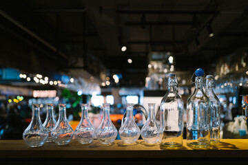 Elegant Display of Glass Bottles and Decanters Illuminated in Ambient Bar Setting