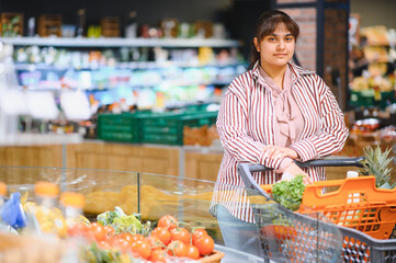 Indian woman choosing fresh produce in grocery store