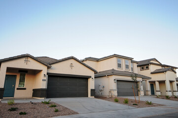 Row of newly built suburban houses with attached garages in a new subdivision, representing residential real estate and homes for sale