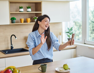 Portrait of a healthy young woman businesswoman enjoying morning in kitchen and taking a selfie...
